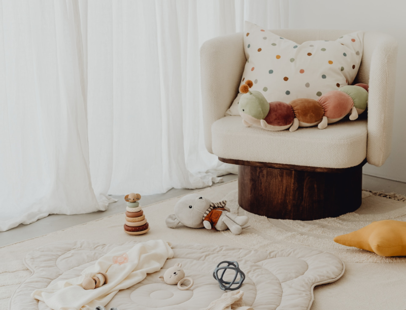 pokój dziecka z fotelem, dywanem i zabawkami